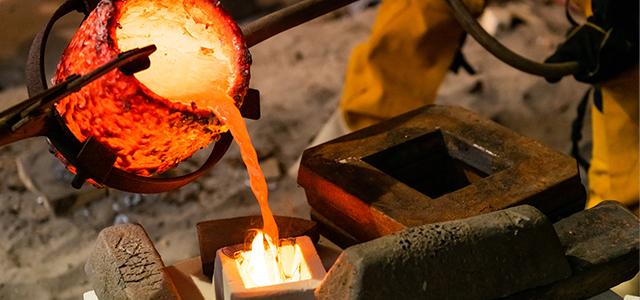 ksu student pouring hot metal into mold